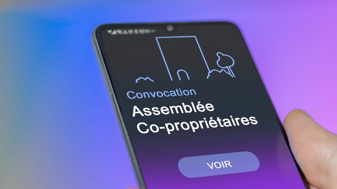 Un co-propriétaire regarde sur son téléphone la convocation d