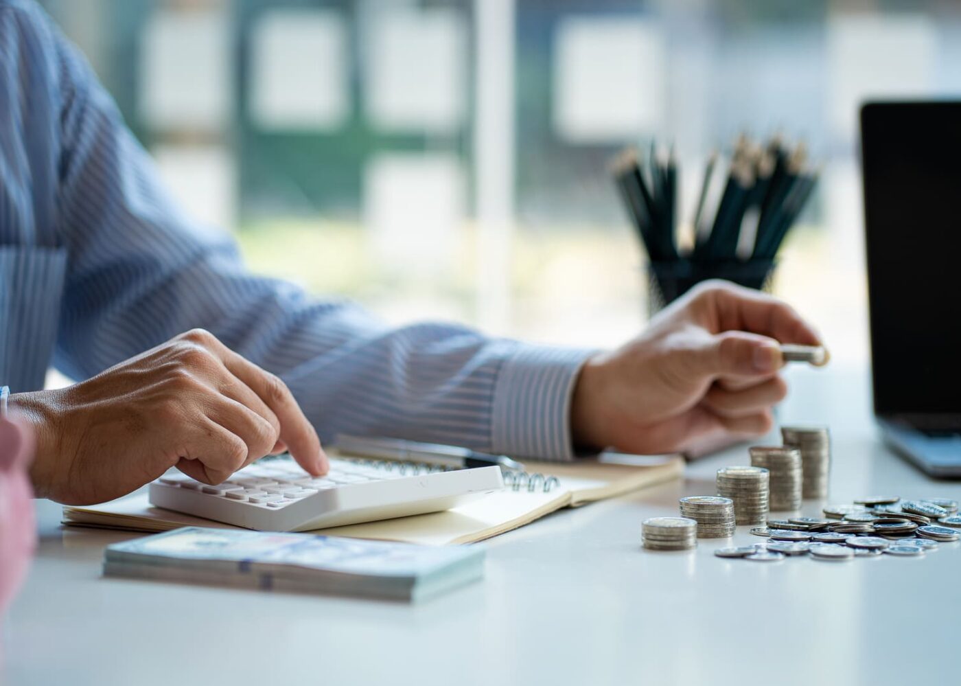 homme qui compte ses économies avec une calculette