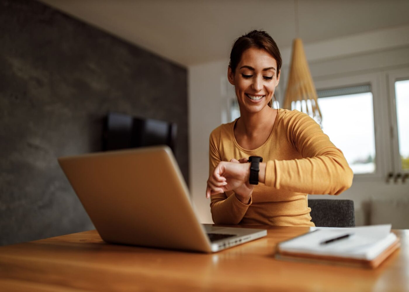 femme devant ordinateur regardant sa montre