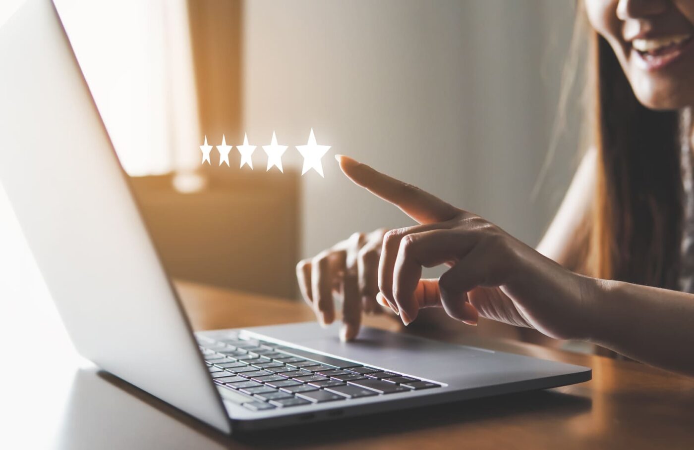 femme devant un ordinateur avec étoiles de satisfaction flottantes